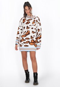 Abito di maglia con un motivo leopardato arancione e marrone su base bianca, con righe blu e arancioni sui polsini e sull'orlo.