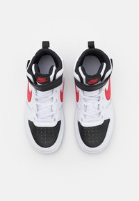 Sneakers Nike de cano alto em couro branco e preto, com detalhes em vermelho, colarinho acolchoado e design com atacadores. Bico perfurado para respirabilidade.