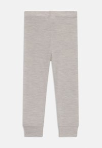 Grå, åtsittande leggings gjorda av ett mjukt, texturerat tyg med en slät yta. De har ett smalt ankelslut och en elastisk midja.