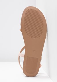 Semelle de sandale avec motifs antidérapants texturés au talon et à l'avant, couleur beige, taille 37, affichée verticalement sur un fond blanc.