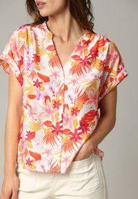 Korte mouwen, knoopsluiting shirt met een multikleurig bloemenpatroon in roze, oranje en geel op een lichte achtergrond. Lichtgewicht stof.