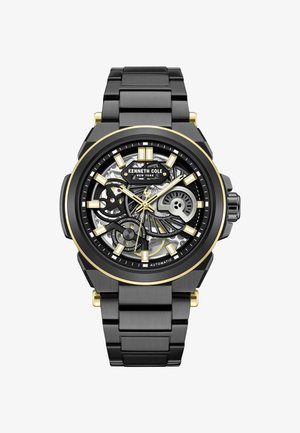 Czarny zegarek ze stali nierdzewnej z czarną i złotą szkieletową tarczą, z luminescencyjnymi znacznikami godzin i czarnym bransoletą ogniwową. Widoczny automatyczny mechanizm.