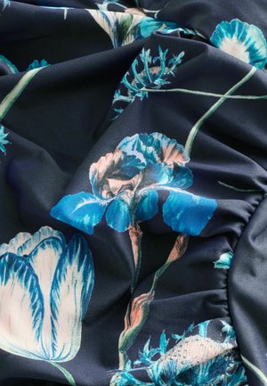 Tissu floral présentant des fleurs bleues et roses sur un fond marine foncé. Le matériau est lisse avec un léger éclat, affichant des détails complexes.