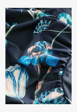 Tessuto floreale con fiori blu e rosa su uno sfondo blu scuro. Il materiale è liscio con una leggera lucentezza, mostrando dettagli intricati.