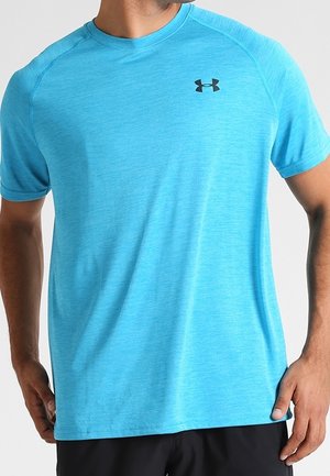 Mann trägt ein hellblaues kurzärmliges Sportshirt mit einem schwarzen Under Armour Logo auf der linken Brust.