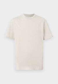 Lys beige bomulds t-shirt med rund hals, korte ærmer og et lille broderet logo på brystet. Enkel, almindelig pasform design.
