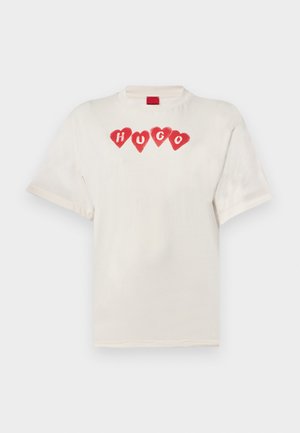 T-shirt en coton crème avec un col rond, des manches courtes et un graphisme de quatre cœurs rouges accompagnés du mot « HUGO » en lettres majuscules sur le devant.