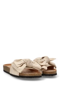 Sandalias beige con detalle de lazo de tela, plantilla de corcho y suela de goma negra. La parte superior presenta un diseño anudado con textura suave.