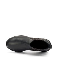 Zapato de cuero negro con un acabado suave, paneles laterales elásticos que presentan un patrón geométrico marrón y una suela de goma resistente.
