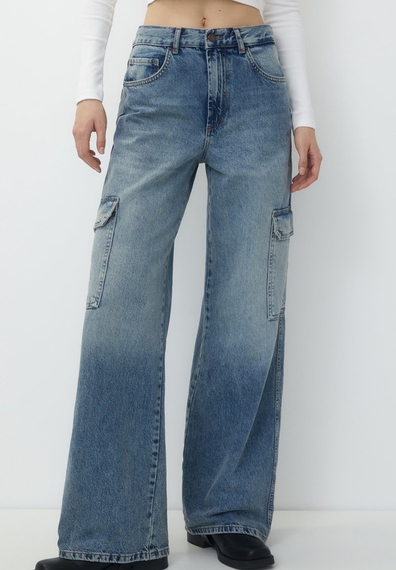 Ljust blå denim cargobyxor med hög midja, vida ben, två sidofickor och en bleknad färggradient. En klassisk femfickorsdesign.