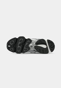 Black and gray New Balance sneaker sole with textured tread patterns and "new balance" logo on a white background.