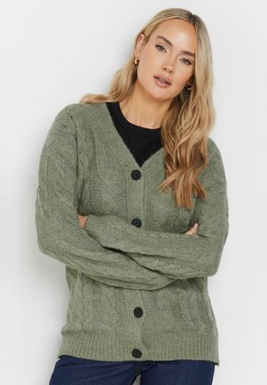 Vihreä neulecardigan, jossa on kaapelikuvio, V-pääntie ja mustat napit. Pitkät hihat, joissa on ribbausrannekkeet ja helma. Pehmeä, teksturoitu kangas.