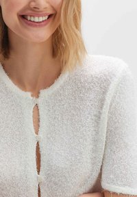 Weißer Strickcardigan aus einem strukturierten, flauschigen Stoff. Kurze Ärmel, runder Halsausschnitt und Knopfverschluss an der Vorderseite. Einfaches Design.