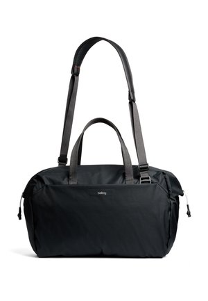 Sac polochon noir en tissu texturé. Comprend deux poignées, une sangle ajustable et un logo discret sur le devant. Design élégant et fonctionnel.