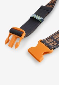 Säädettävä mustasta kankaasta valmistettu hihna, jossa oranssi muovinen solki ja koristeellisia yksityiskohtia; hihnan pituudella kulkee koristekuvio.