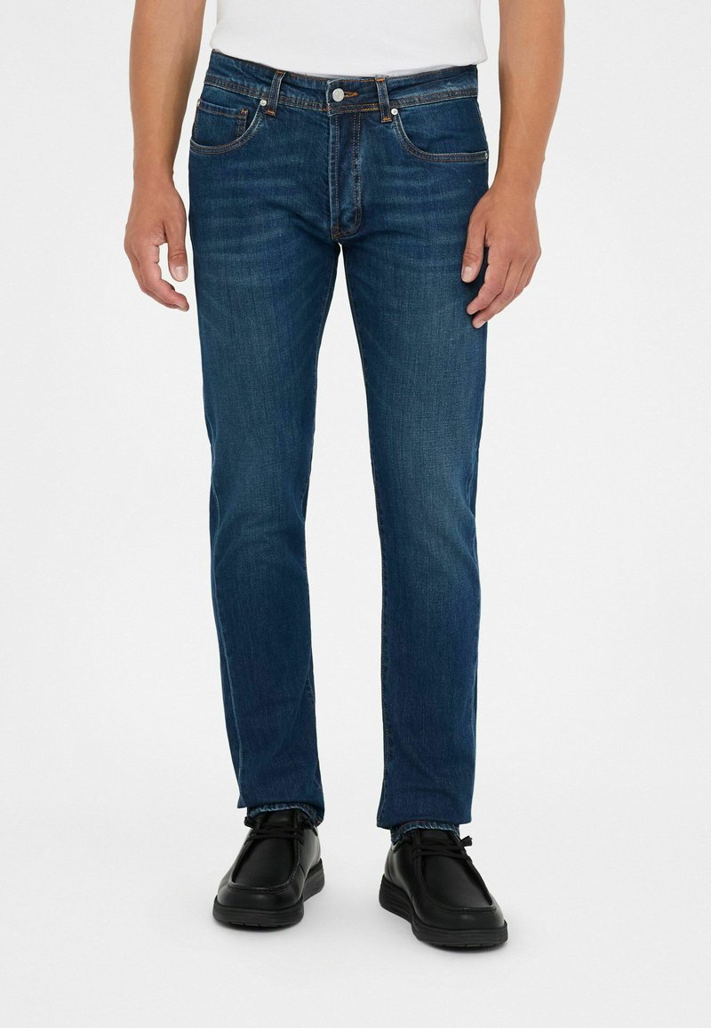 Jeans de mezclilla azul oscuro con corte recto, diseño de cinco bolsillos, detalles de costura sutil y cierre de botón en la cintura.
