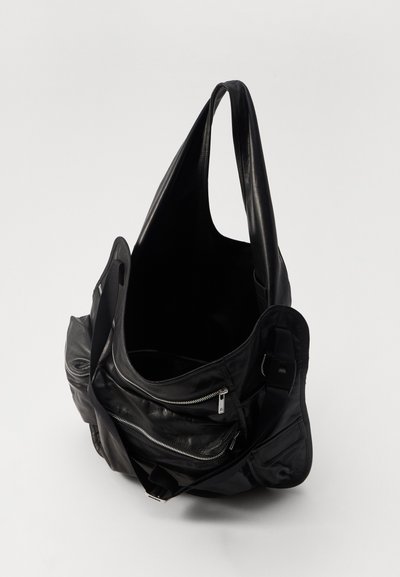 Sorte læder tote-bag med en blød tekstur, som har et rummeligt indre, store skulderremme og lynlåslommer på fronten.