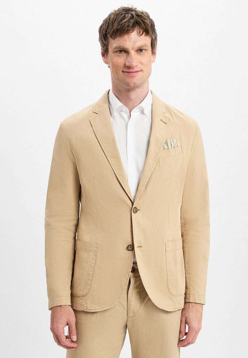 Blazer beige su misura in tessuto leggero, con due bottoni, rever a punta e tasche frontali. Include un fazzoletto per taschino con motivo.