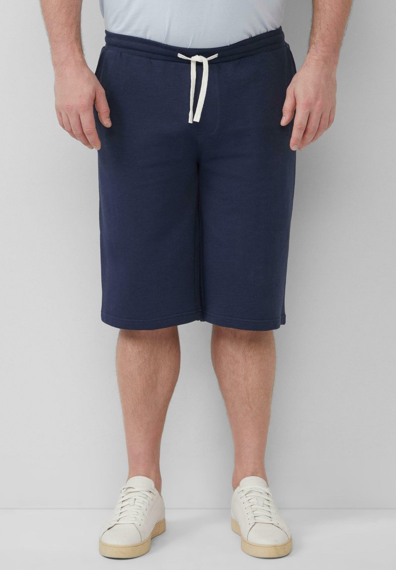 Shorts en coton bleu marine avec taille élastique et cordons blancs. Texture lisse, design jusqu'aux genoux et sans motifs visibles.