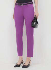 Vibrant purple tailored pants with a smooth texture and slim fit, paired with a black shiny handbag and pointed-toe heels.