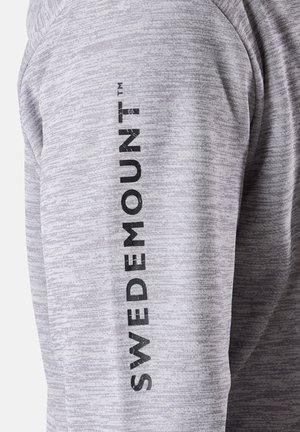 Grijs gemêleerd overhemd met lange mouwen en een verticale zwarte "SWEDEMOUNT" logo langs de arm. De stof heeft een gladde textuur.