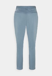 Pantalon bleu clair à jambe droite avec poches passepoilées à l’arrière et passants de ceinture, présenté sur un fond blanc uni.