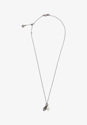 Collar de cadena de plata con cuenta de rayas negras y blancas y colgantes de perlas blancas irregulares sobre un fondo blanco.