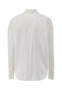 Camicia bianca a maniche lunghe con un motivo a pois testurizzato, colletto classico e polsini con bottoni. Vestibilità comoda con un design della schiena dritta.