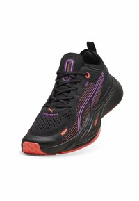 Baskets de sport noires avec des accents violets et oranges, dotées d'une tige en mesh respirant, d'une semelle rembourrée et d'une semelle extérieure à traction texturée.
