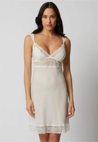 Camisón de tul blanco con detalles de encaje, con tirantes ajustables, que presenta un cuerpo transparente y una falda suave y delicada que termina en un dobladillo de encaje.