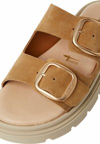 Brown suede sandal with two adjustable straps, featuring gold-tone buckles. Soft footbed and chunky beige sole with textured tread.
