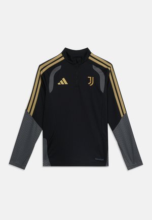 Haut de sport noir à manches longues avec des bandes dorées sur les épaules, manches inférieures grises, logos Adidas et Juventus, et une courte fermeture éclair à l'avant.