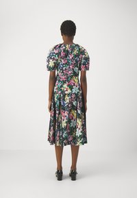 Abito floreale con maniche a sbuffo corte, caratterizzato da uno sfondo nero e fantasie di fiori multicolore. Gonna a pieghe e chiusura con zip sul retro.