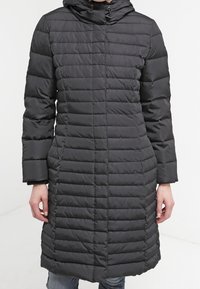 Black, quilted puffer coat with a hood, featuring horizontal stitching, long sleeves, and a straight hem. Durable, water-resistant material.