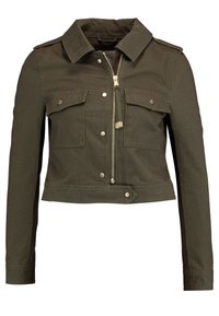 Oliwkowa krótka kurtka wykonana z wytrzymałego materiału, z kołnierzem, dwiema przednimi kieszeniami, zapięciem na zamek błyskawiczny oraz srebrnymi elementami wykończenia.