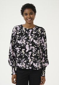 Blusa a maniche lunghe nera con un motivo astratto rosa e crema, scollatura rotonda e polsi aderenti. Tessuto morbido e testurizzato.