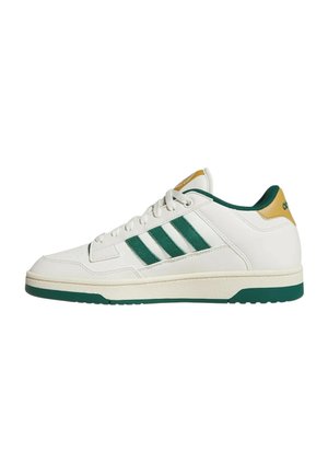 Scarpa da ginnastica bianca con strisce verdi e suola, dettaglio giallo sul tallone e lacci bianchi, mostrata di lato su sfondo bianco.