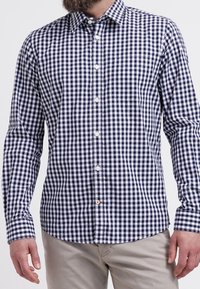 Camicia a quadro gingham blu navy e bianco, con colletto a punta, maniche lunghe e taschino sul petto, realizzata in tessuto tessuto.
