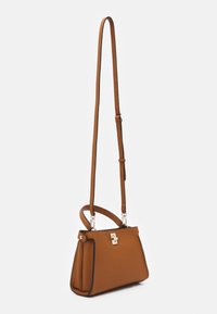 Sac à main en cuir marron texturé avec un fermoir en argent, une bandoulière réglable et une forme structurée, dotée d'une petite poignée sur le dessus.