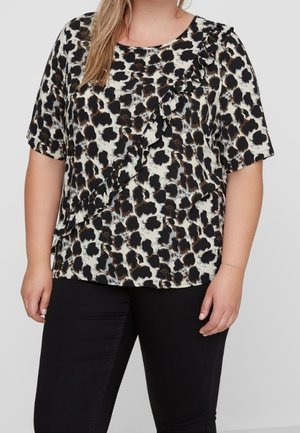 Blusa de manga corta con un estampado abstracto de animal en negro, marrón y crema, con un detalle de volantes en la parte delantera. Textura de tela suave.