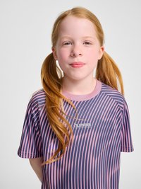 Young girl with red hair in pigtails wearing a purple and pink striped sports shirt, looking directly at the camera against a white background.