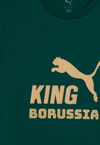 Mørkegrøn skjorte med beige Puma-logo af en springende puma og fed beige tekst "KING BORUSSIA" under logoet.