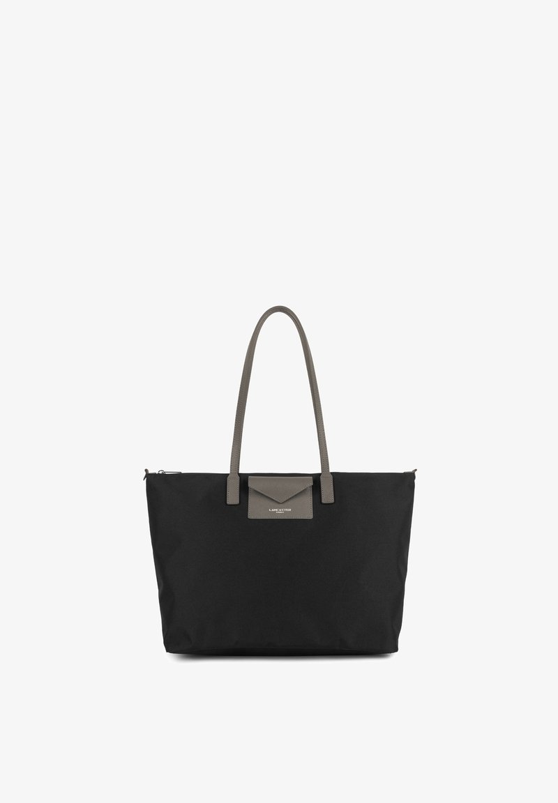 Sac cabas noir avec de longues anses grises et un petit rabat gris sur la poche avant avec le nom de la marque visible.