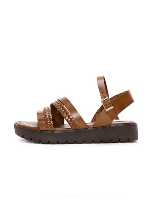 Sandalo in pelle marrone con cinturini intrecciati, fibbia regolabile alla caviglia, suola piatta in gomma marrone, soletta texturizzata e design open-toe.