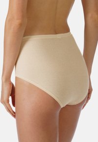 Beige bomullstrosor med hög midja och en slät textur. Har en bred midjeresår och elastiska kanter för en åtsittande passform.