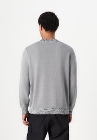 Gray knit sweater with a textured pattern at the collar and hem. Features long sleeves and a relaxed fit. Soft fabric.