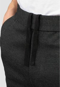 Svarta, texturerade joggers med dragsko i midjan och sidofickor, med ett subtilt fiskbensmönster. Mjukt tyg för komfort.
