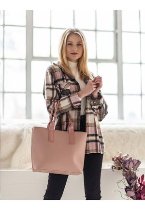 Rosa Tragetasche mit zwei Griffen, glatter Textur, rechteckiger Form, minimalem Zubehör, kombiniert mit einem karierten Hemd mit Knöpfen und schwarzen Hosen.