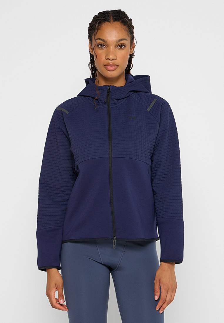 Marineblauwe hoody met een ritssluiting aan de voorkant, textuurpanelen op de schouders en grijze accenten. Zacht materiaal en een ontspannen pasvorm.