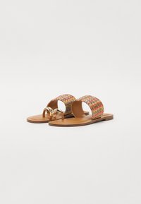 Des sandales plates avec une sangle tissée multicolore et un matériel doré. La semelle est en matériau synthétique de couleur brun clair, offrant un design décontracté.